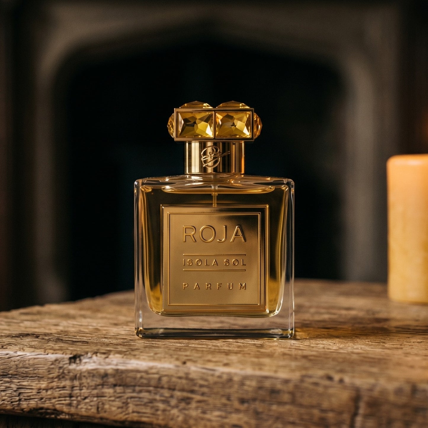 Roja Isola Sol Parfum on walnut side table with a pair of lit votives beside the bottle