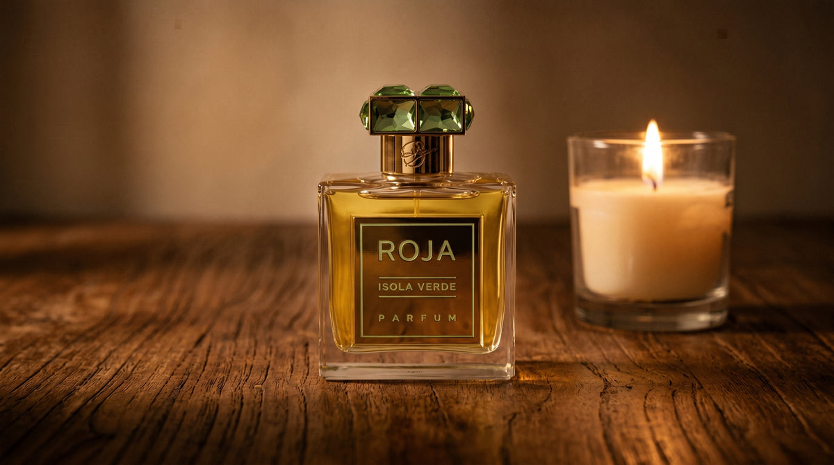 Roja Isola Verde Parfum on aged teak with a candle burning gently to frame-right