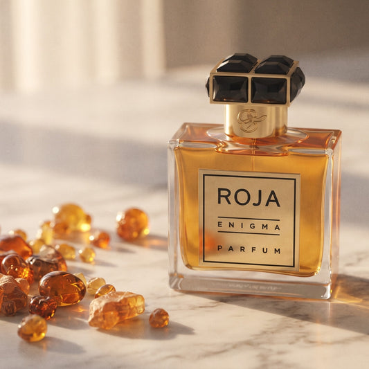 Roja Parfums Enigma Pour Homme Parfum on pale grey marble with amber resin beads scattered to one side
