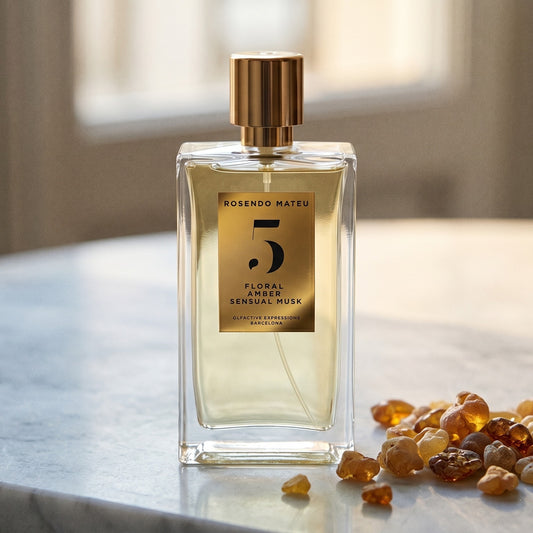 Rosendo Mateu No. 5 EDP on warm ivory travertine with labdanum chunks clustered by the base