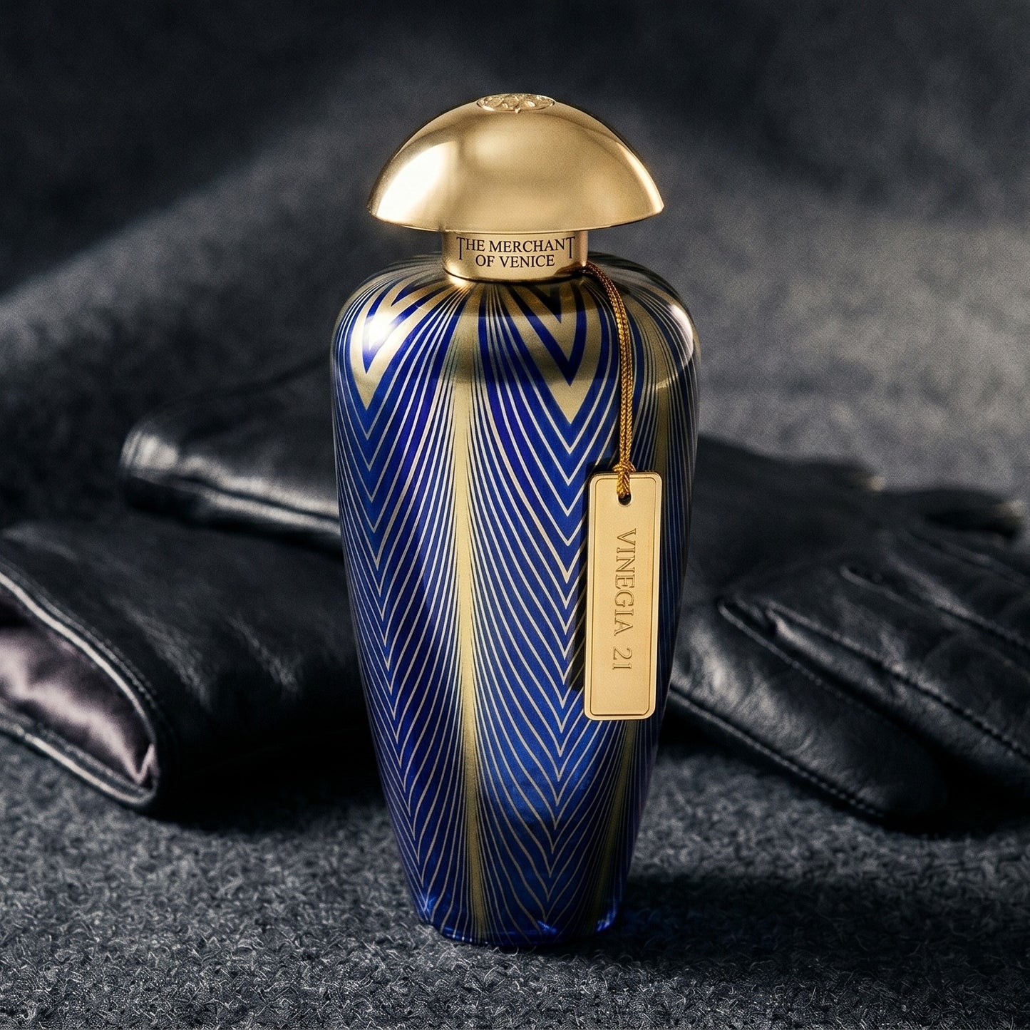The Merchant of Venice Vinegia 21 EDP on deep charcoal linen with a leather-strapped wristwatch lying flat