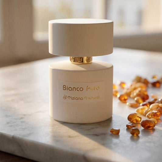 Tiziana Terenzi Bianco Puro on cream stone with a scatter of honey-colored ambergris flakes