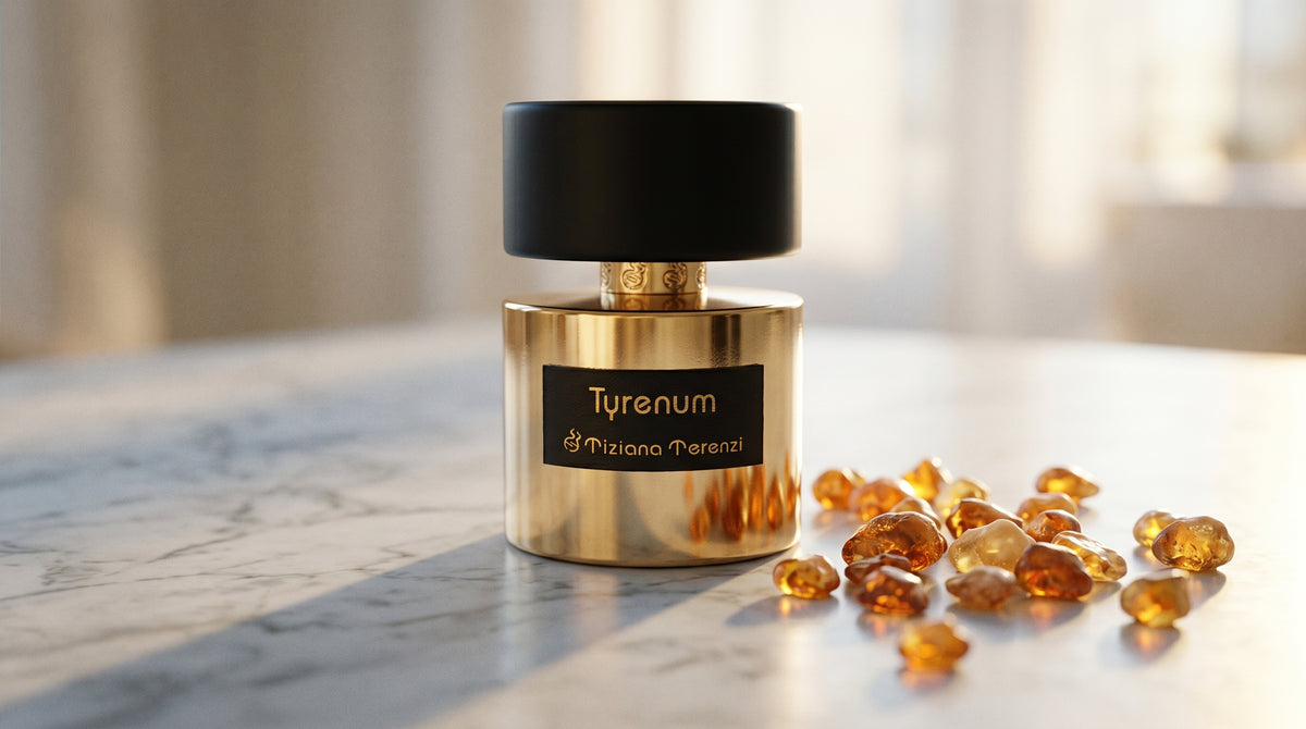 Tiziana Terenzi Tyrenum EDP on pale grey marble with amber resin beads scattered to one side