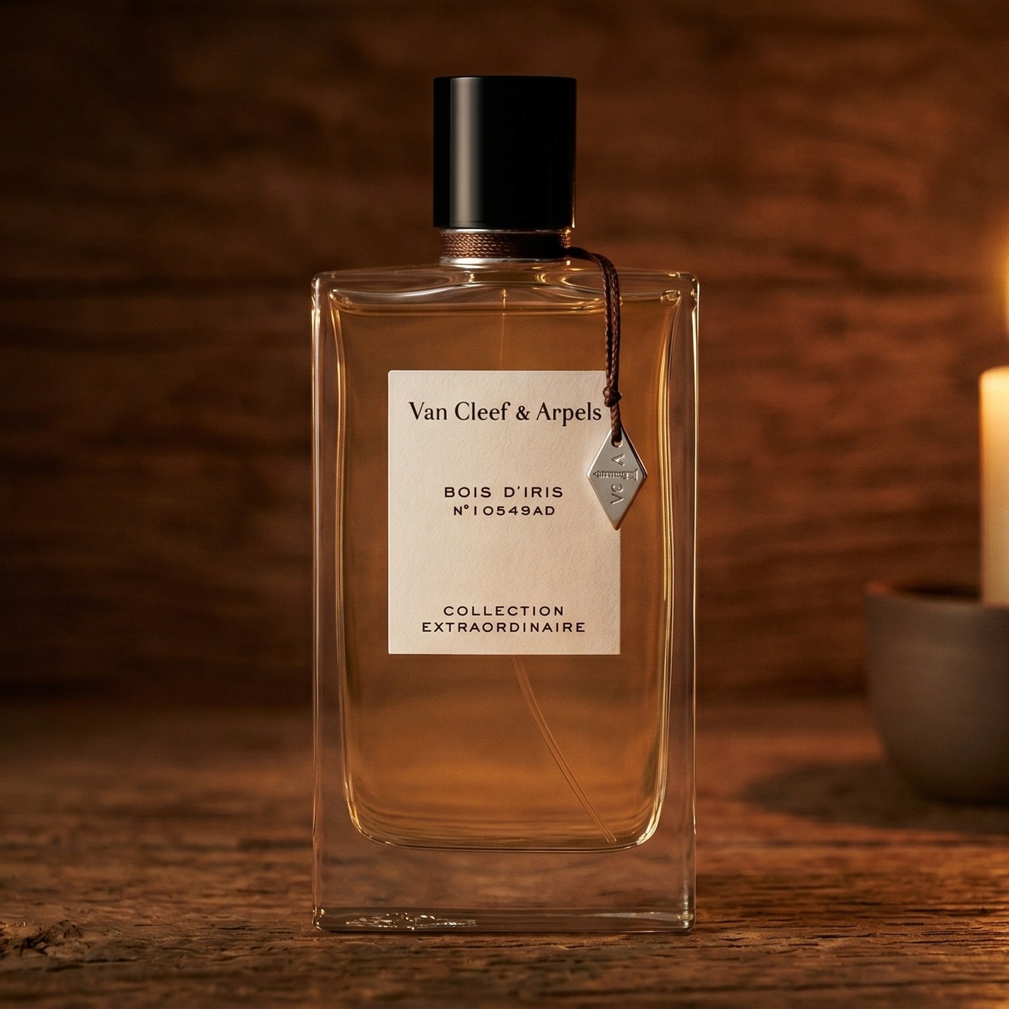 Van Cleef Bois Diris EDP on reclaimed oak surface with a glass hurricane lamp softly glowing