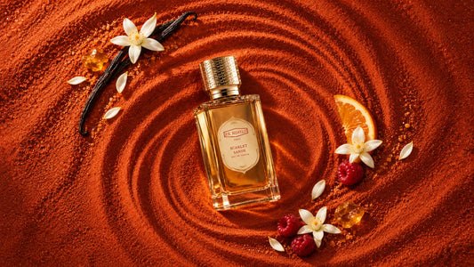 Ex Nihilo Scarlet Sands EDP bottle on swirled terracotta sand with raspberries, orange blossom, vanilla pods and a slice of orange