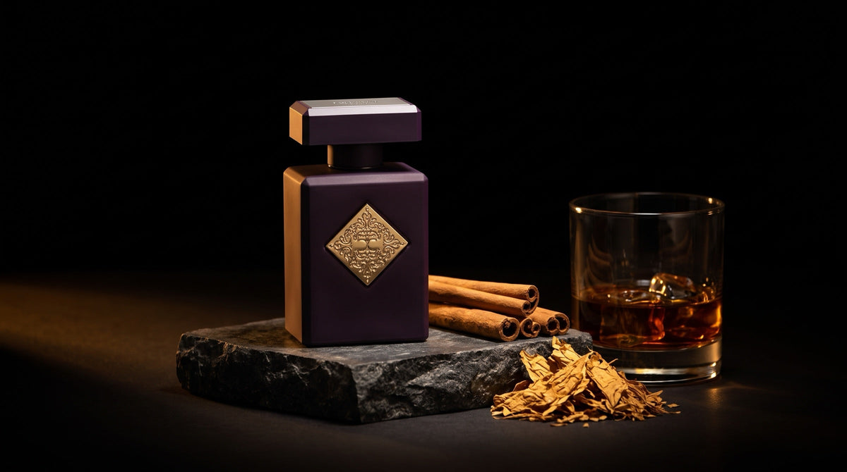 Initio Side Effect eau de parfum on dark stone with cinnamon sticks, tobacco leaves and a glass of amber rum