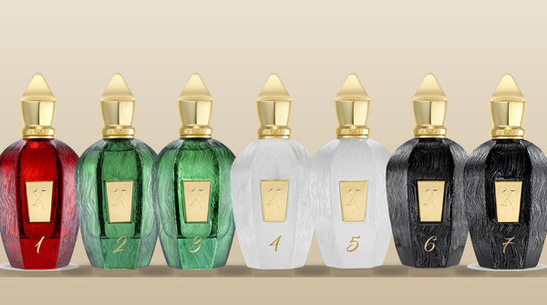 All seven Xerjoff UAE Exclusive bottles in a row, numbered 1 to 7, in red, green, white and black glass with gold caps