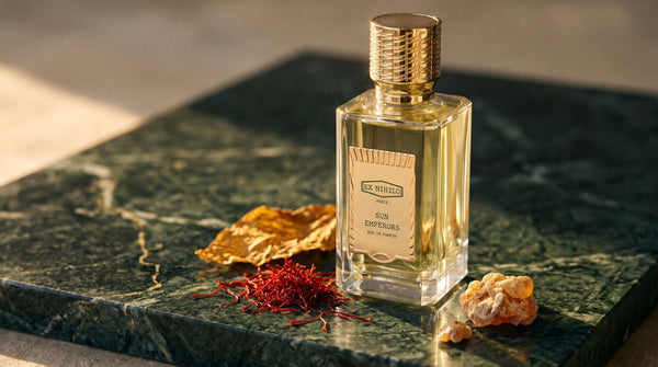 Ex Nihilo Sun Emperors Eau de Parfum on deep green marble in low golden light with saffron threads, a dried tobacco leaf and benzoin resin