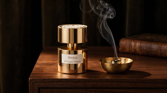 Tiziana Terenzi Arrakis gold bottle on a walnut table beside a smoking brass bowl and old books