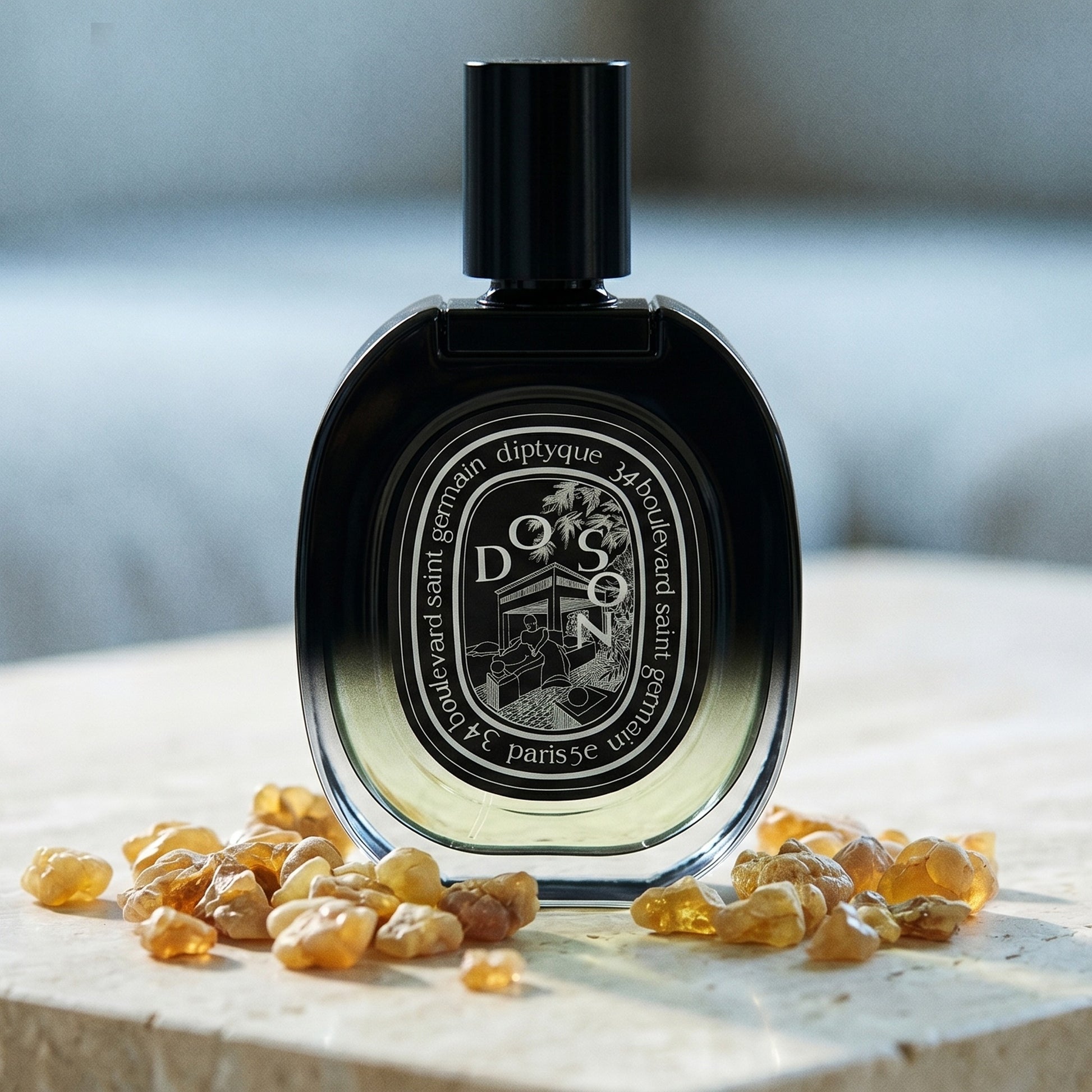 Diptyque Doson EDP on polished limestone with benzoin resin pebbles arranged loosely