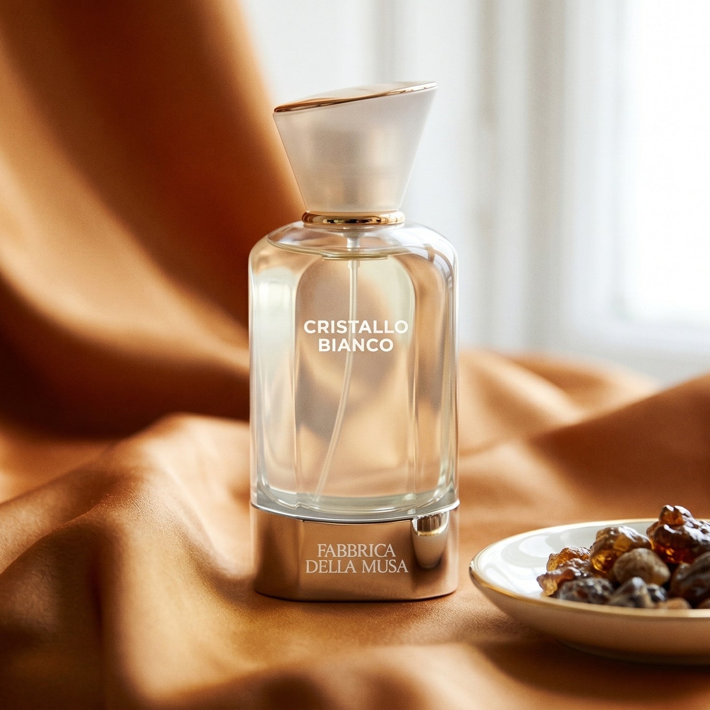Fabbrica Della Musa Cristallo Bianco EDP on amber-toned satin with a gold-rim ceramic dish of labdanum