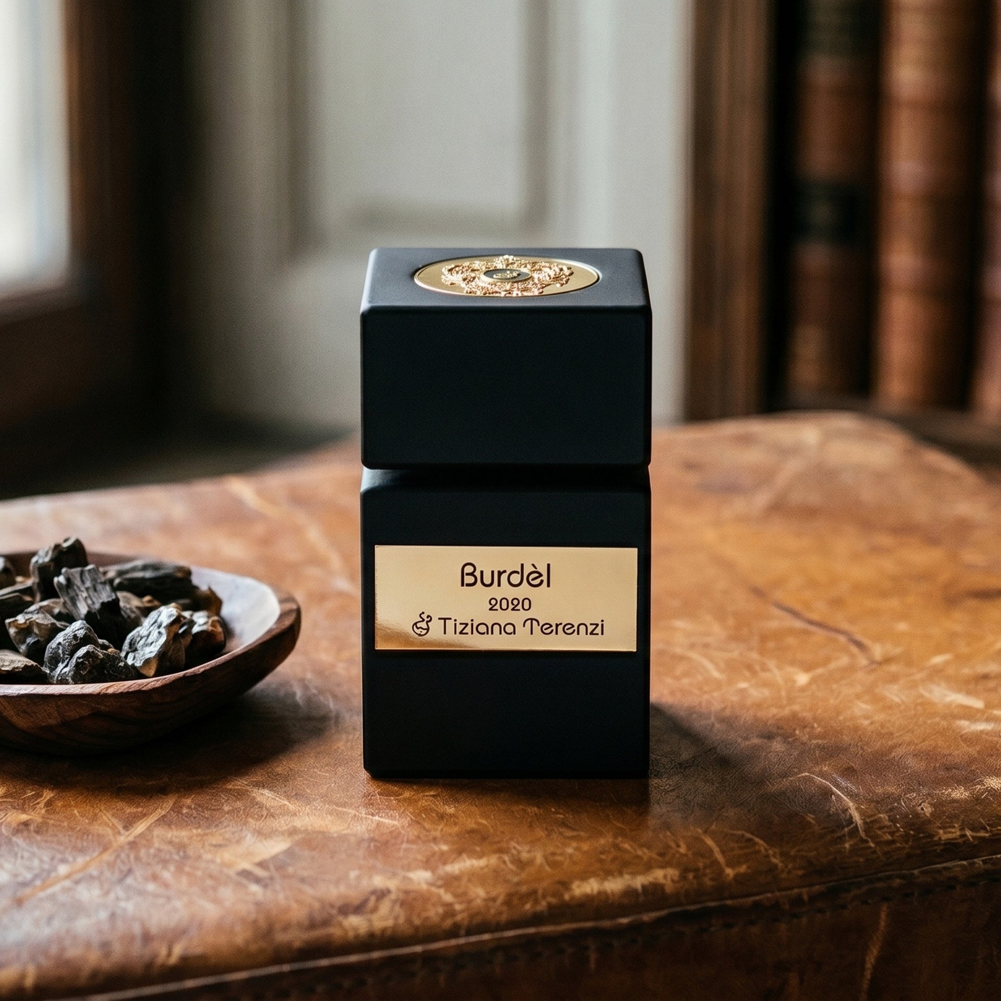 Tiziana Terenzi Burdel EDP on worn saddle-leather surface with oud resin chunks in a small dish