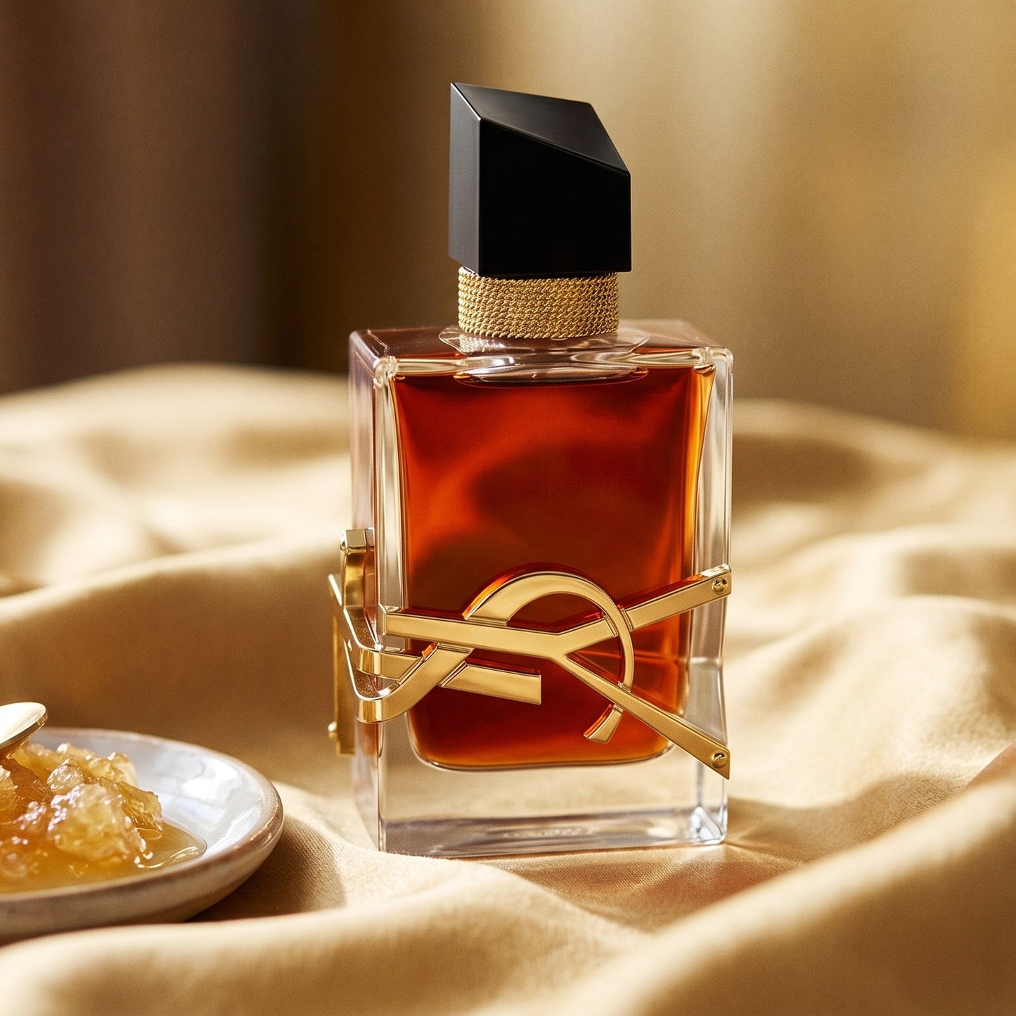 Yves Saint Laurent Libre EDP on golden silk with a small dish of crystallized honey