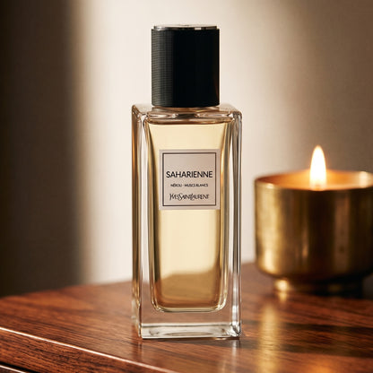 Yves Saint Laurent Saharienne on rosewood surface with a squat brass candle flickering nearby