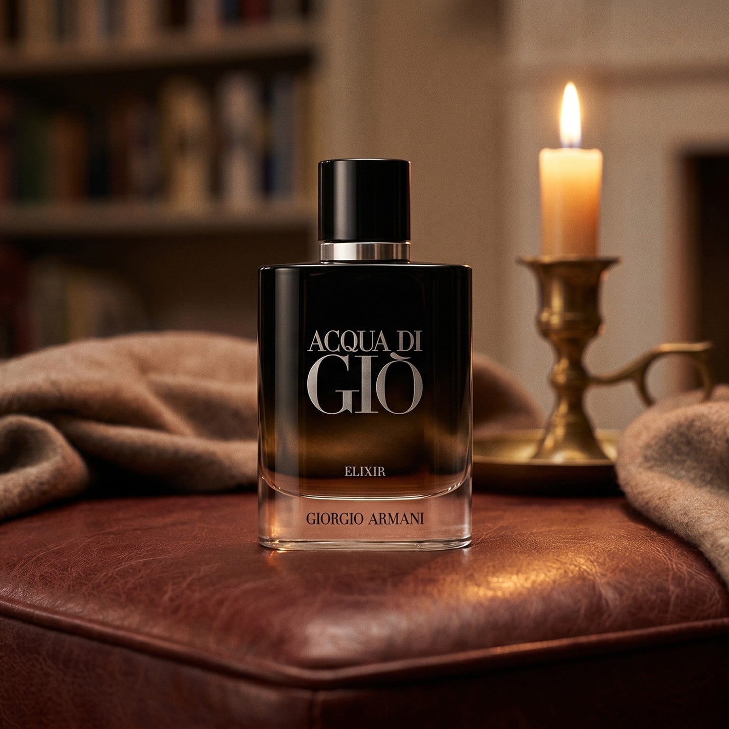 Acqua di Gio Elixir on oxblood leather footstool with a cashmere throw gathered nearby