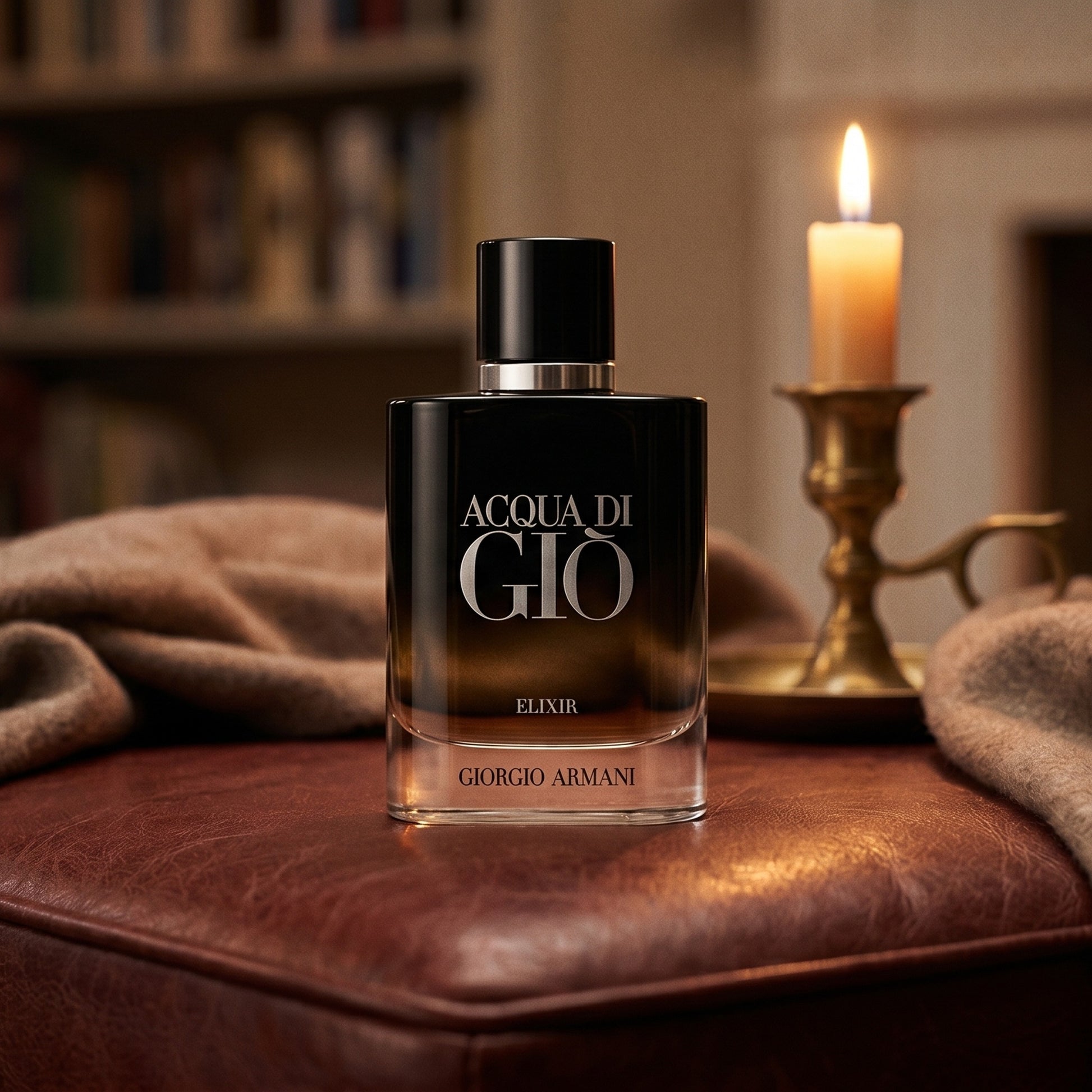 Acqua di Gio Elixir on oxblood leather footstool with a cashmere throw gathered nearby