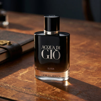 Acqua di Gio Elixir on worn tobacco leather desk with a leather-bound notebook nearby