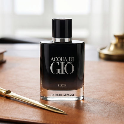 Acqua di Gio Elixir on tanned leather desk blotter beside a brass letter opener