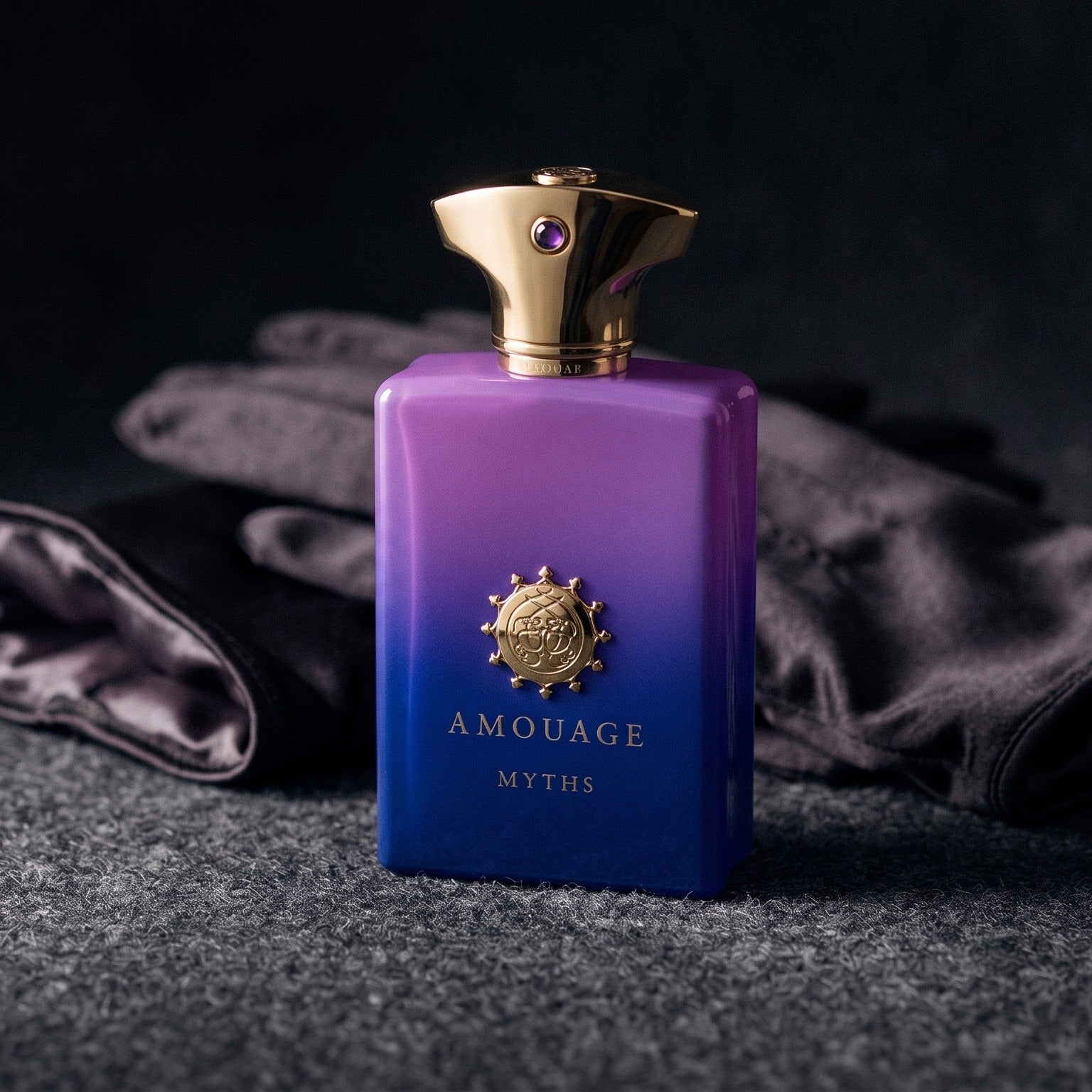 Amouage Myths Man on charcoal felt with a silk-lined glove just behind the bottle