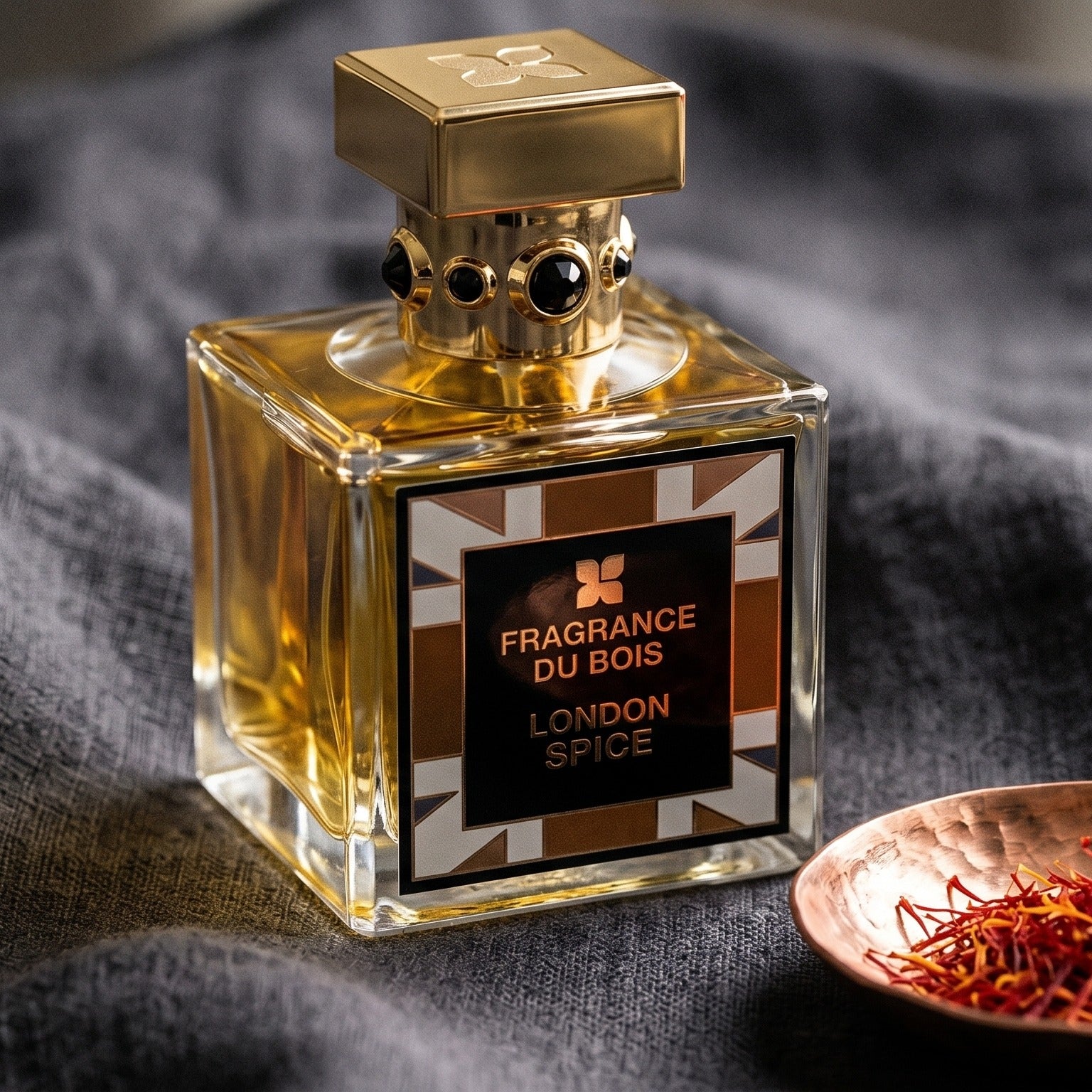Fragrance Du Bois London Spice on charcoal linen with a small copper bowl of saffron threads