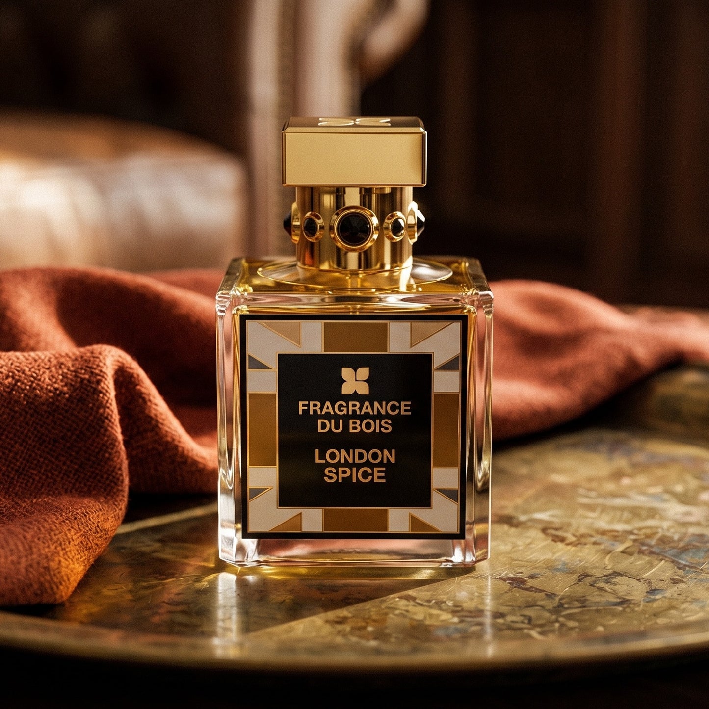 Fragrance Du Bois London Spice on aged brass tray with a folded pashmina in rust tone