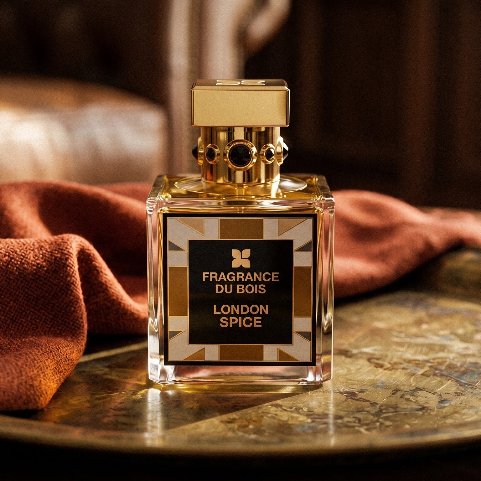 Fragrance Du Bois London Spice on aged brass tray with a folded pashmina in rust tone