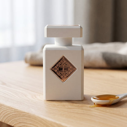 Initio Lift Me Up Extrait de Parfum on pale beech wood with a small porcelain spoon with honey