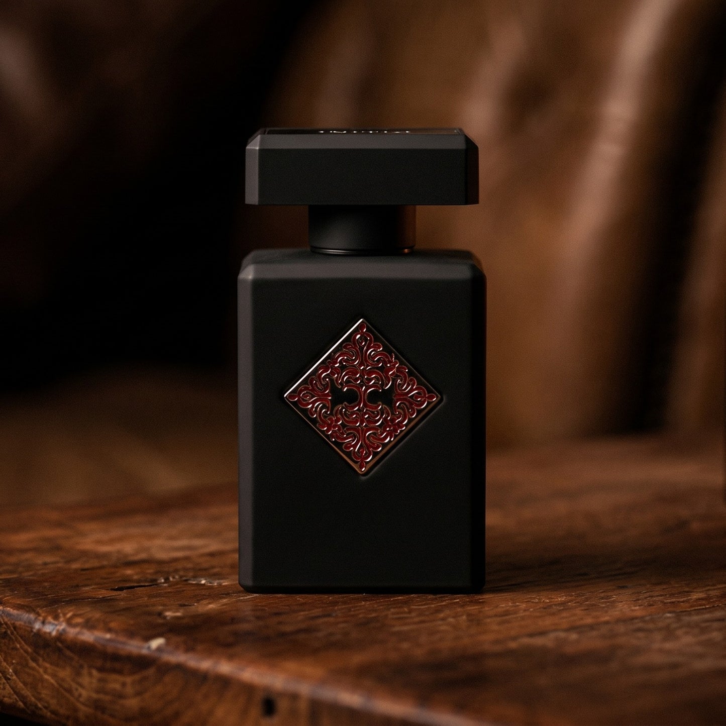 Initio Mystic Experience EDP on aged teak with a candle burning gently to frame-right