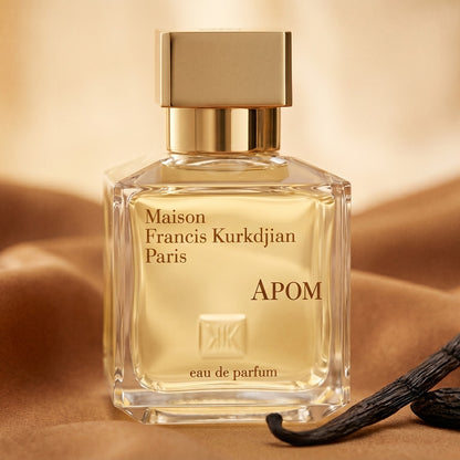 Maison Francis Kurkdjian (MFK) Apom EDP on warm caramel silk with a vanilla pod and tonka bean beside the bottle
