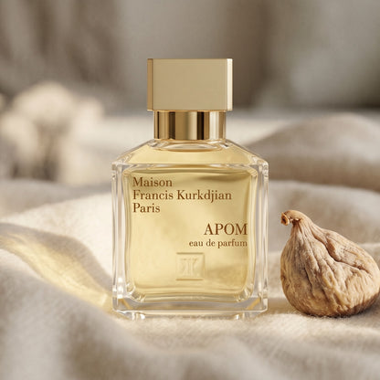 Maison Francis Kurkdjian (MFK) Apom EDP on cream cashmere with a single dried fig beside the bottle