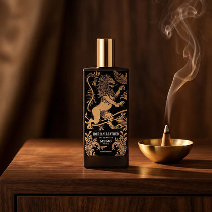 Memo Paris Iberian Leather EDP on dark walnut console with a small brass incense bowl with smoke curling upward