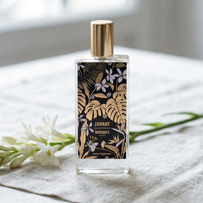Memo Paris Jannat EDP on bleached linen with a single tuberose stem laid flat