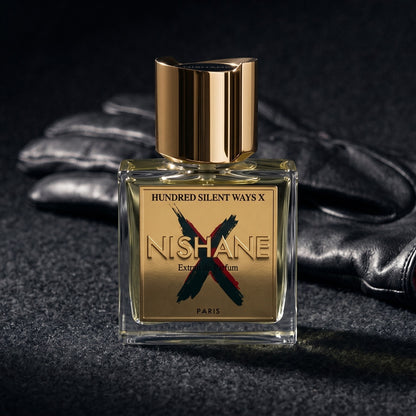 Nishane Hundred Silent Ways X Extrait on charcoal felt with a silk-lined glove just behind the bottle