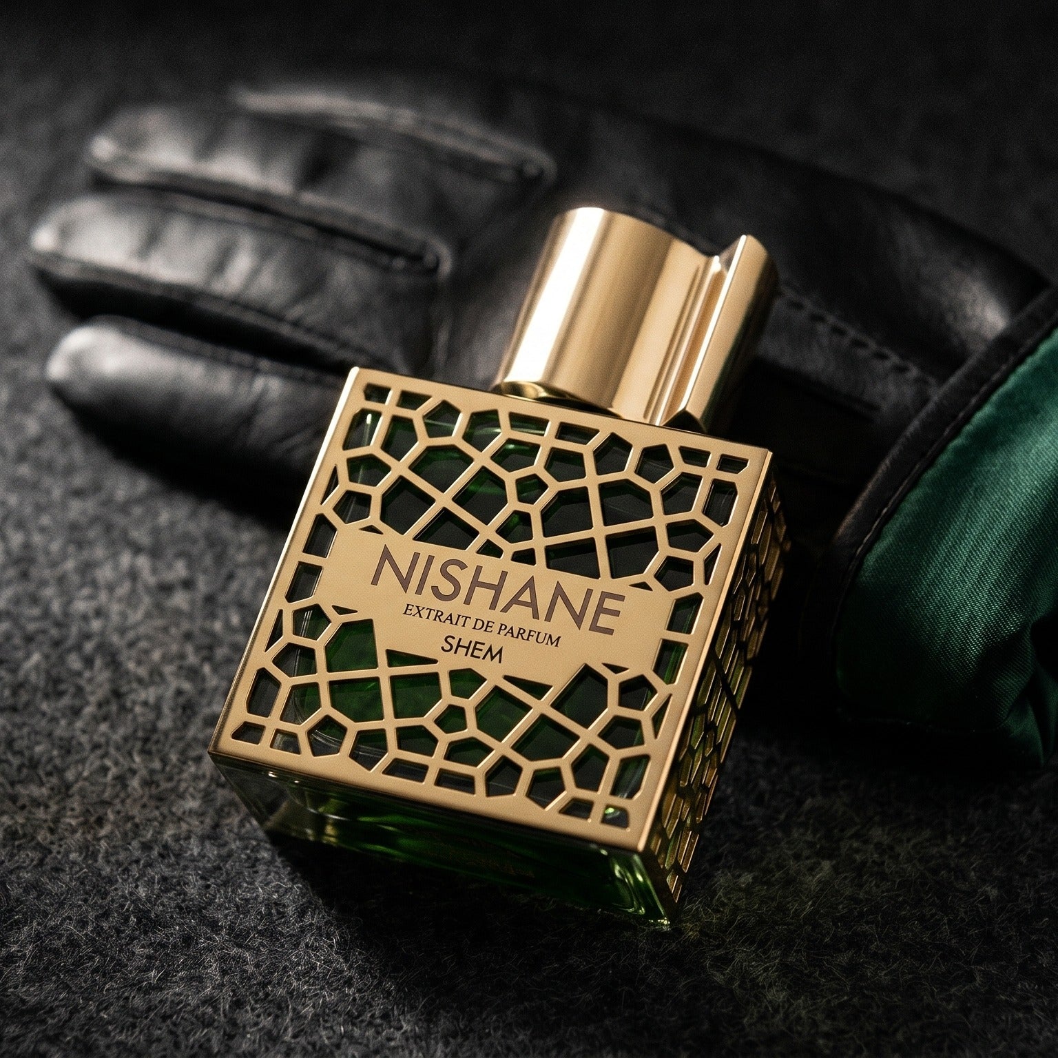 Nishane Shem EDP on charcoal felt with a silk-lined glove just behind the bottle