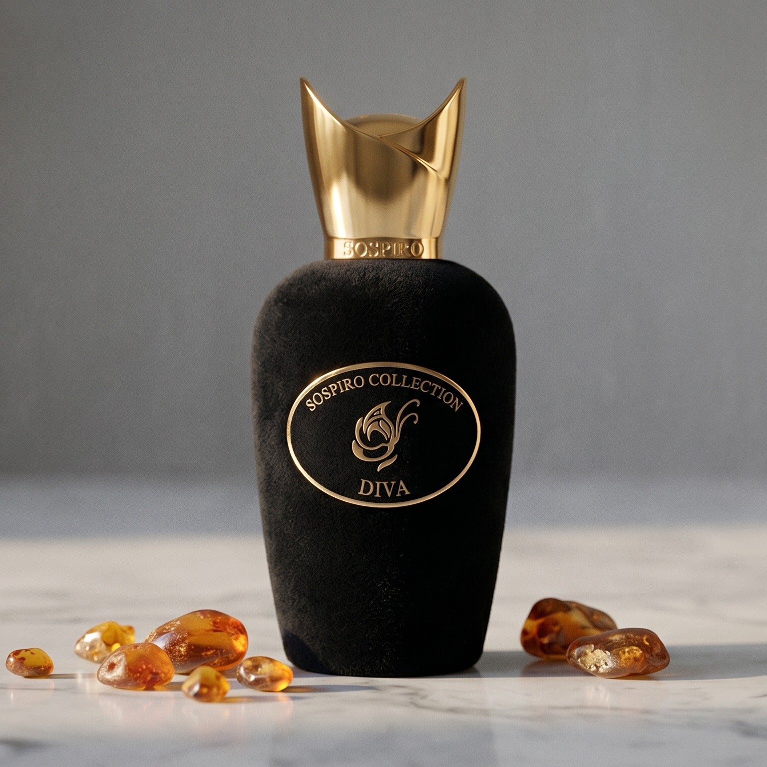 Sospiro Diva EDP on pale grey marble with amber resin beads scattered to one side