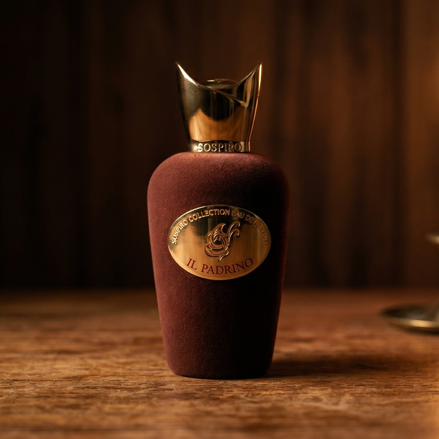 Sospiro IL Padrino EDP on aged teak with a candle burning gently to frame-right