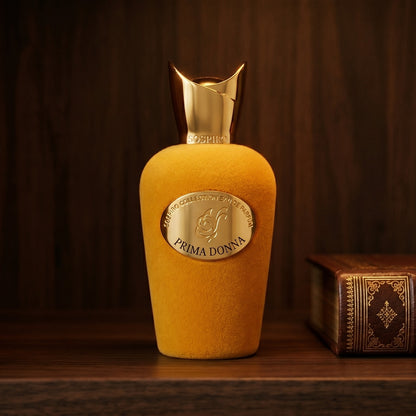 Sospiro Prima Donna EDP on dark walnut library shelf with a leather-bound book with gold foil