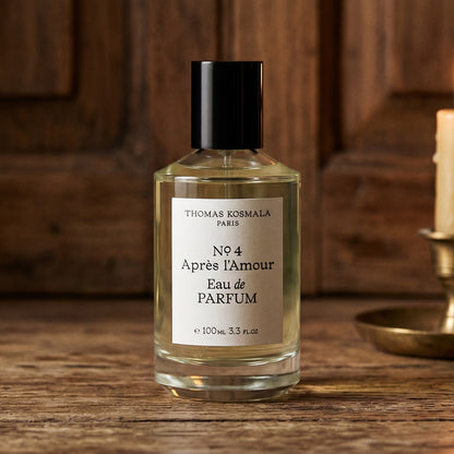 Thomas Kosmala Apres LAmour No 4 EDP on aged teak with a candle burning gently to frame-right