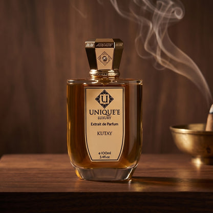Unique Luxury Kutay Extrait on dark walnut console with a small brass incense bowl with smoke curling upward