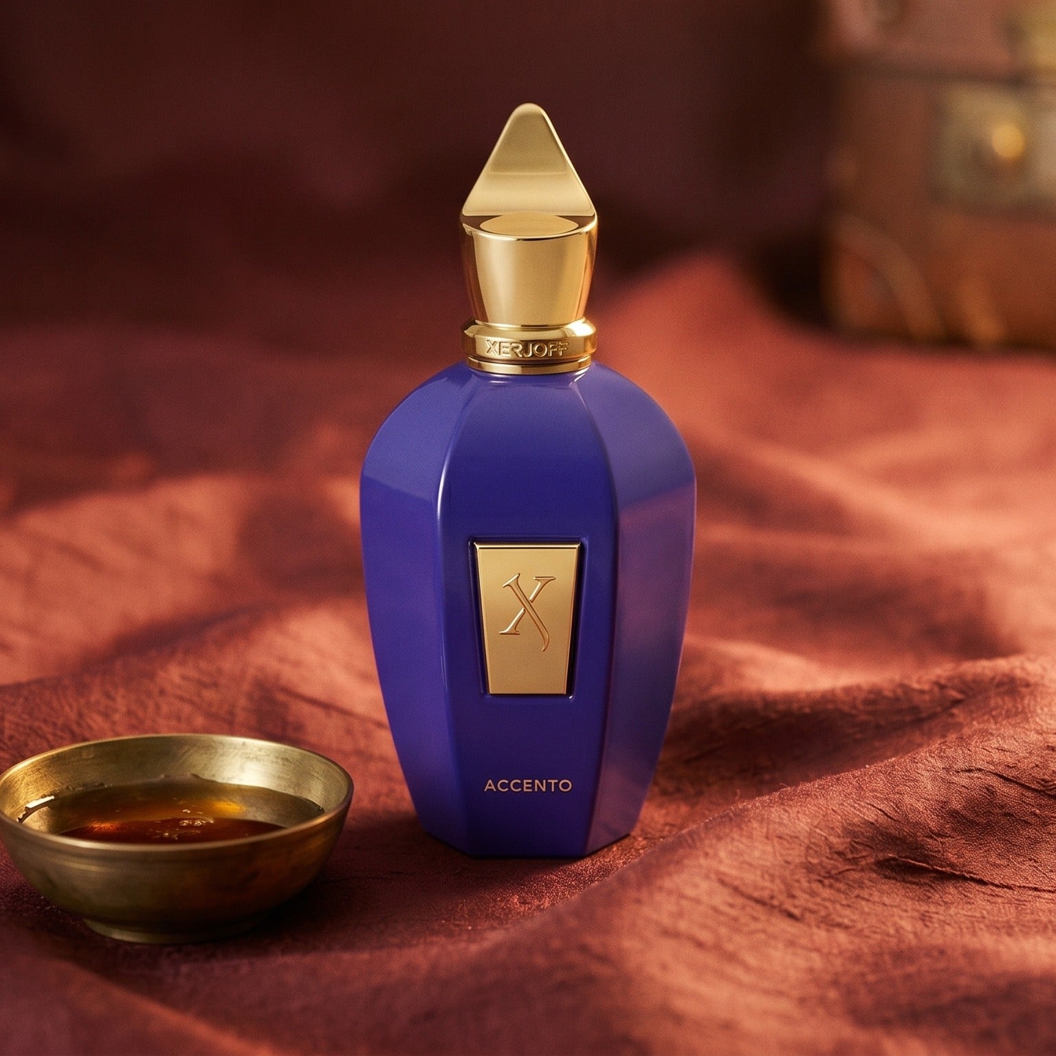 Xerjoff Accento EDP on raw silk of oxblood color with a brass bowl with ambergris tincture