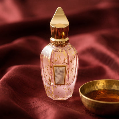 Xerjoff Elle Anniversary Parfum on raw silk of oxblood color with a brass bowl with ambergris tincture