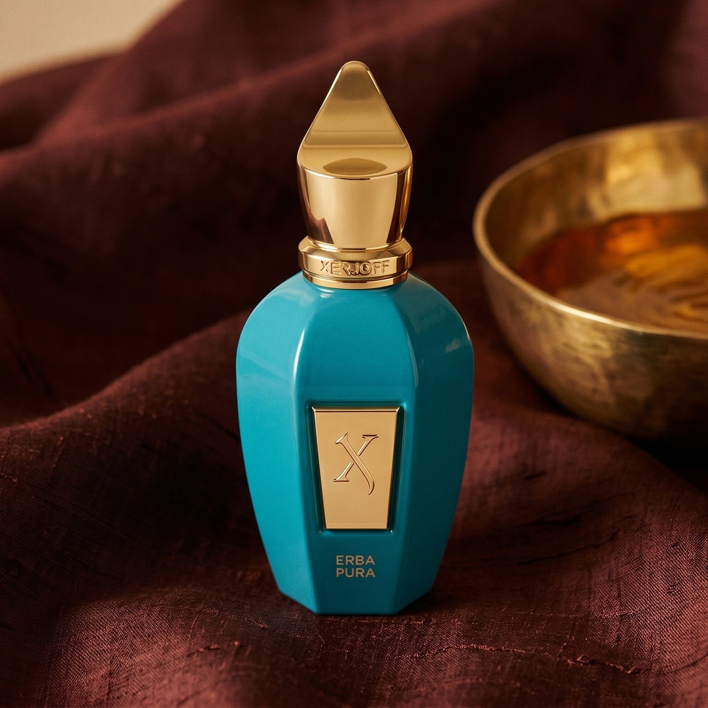 Xerjoff Erba Pura EDP on raw silk of oxblood color with a brass bowl with ambergris tincture