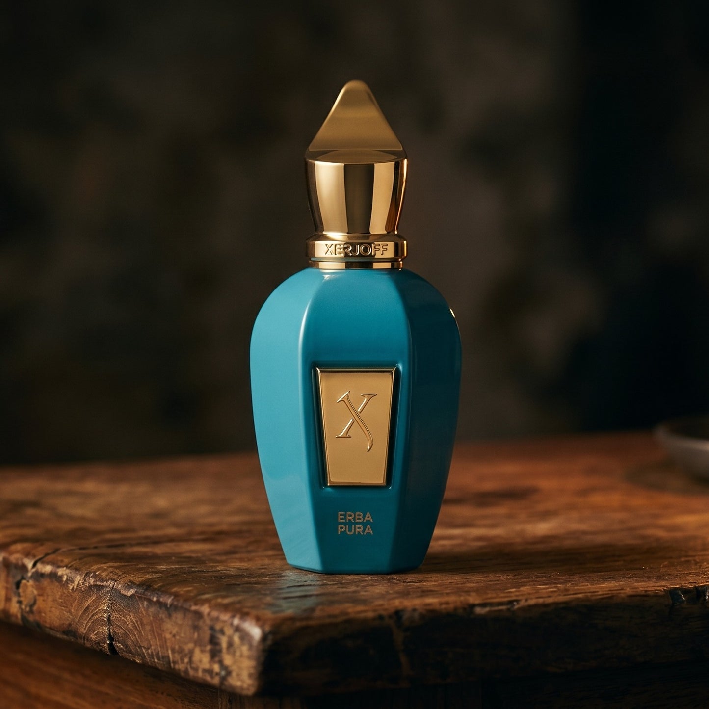 Xerjoff Erba Pura EDP on aged teak with a candle burning gently to frame-right
