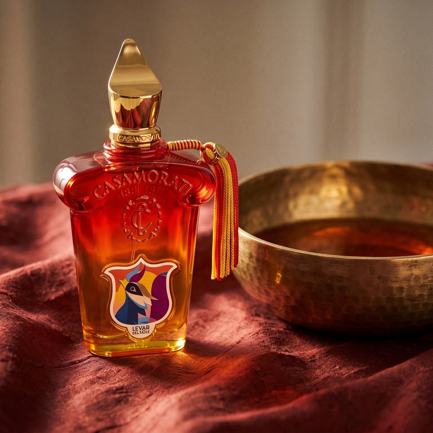 Xerjoff Levar Del Sole EDP on raw silk of oxblood color with a brass bowl with ambergris tincture