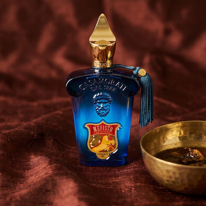Xerjoff Mefisto EDP on raw silk of oxblood color with a brass bowl with ambergris tincture