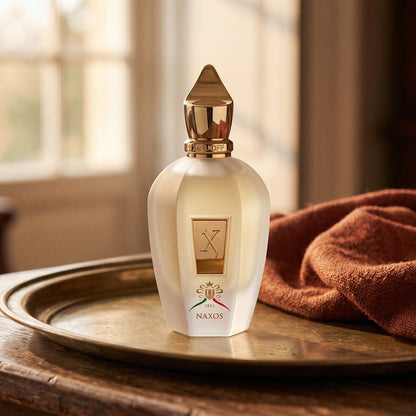 Xerjoff Naxos EDP on aged brass tray with a folded pashmina in rust tone