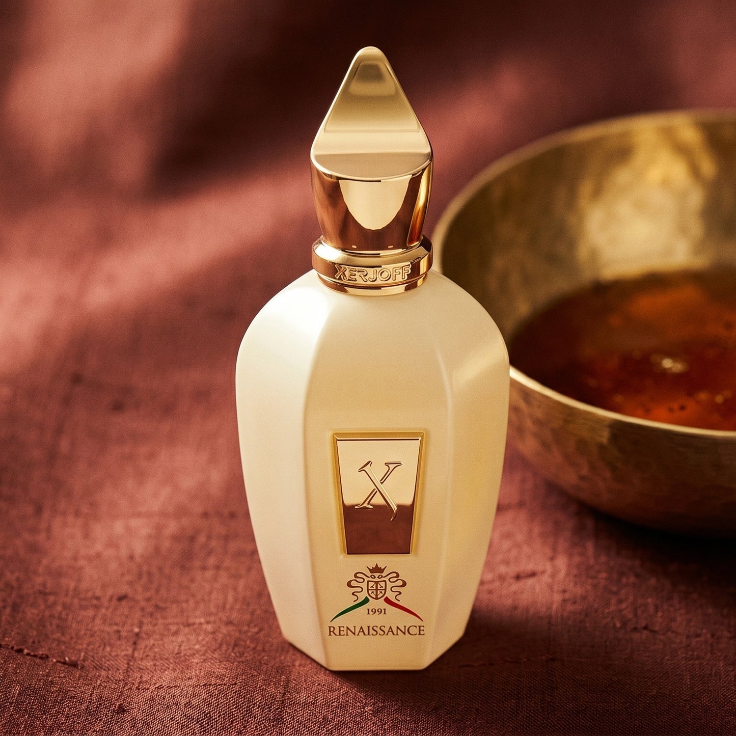 Xerjoff Renaissance EDP on raw silk of oxblood color with a brass bowl with ambergris tincture