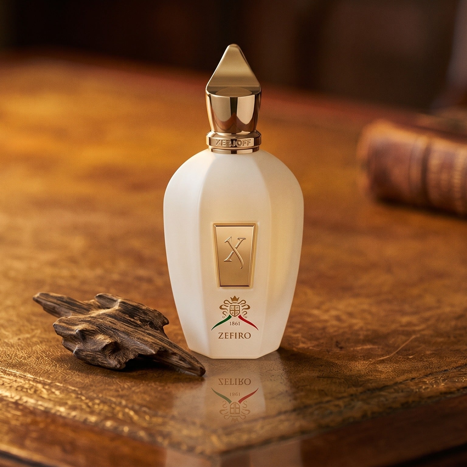 Xerjoff Zefiro EDP on aged leather-topped desk with a single agarwood chip beside the bottle