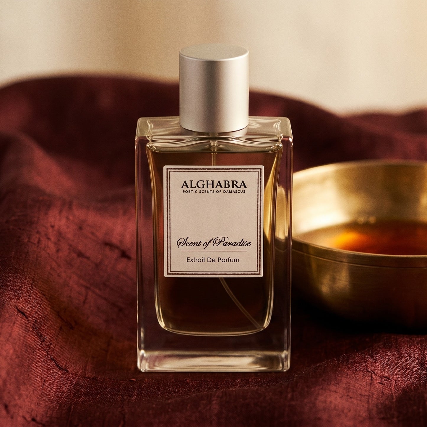 Alghabra Scent of Paradise EDP on russet silk with a matte brass bowl holding tonka and amber pieces