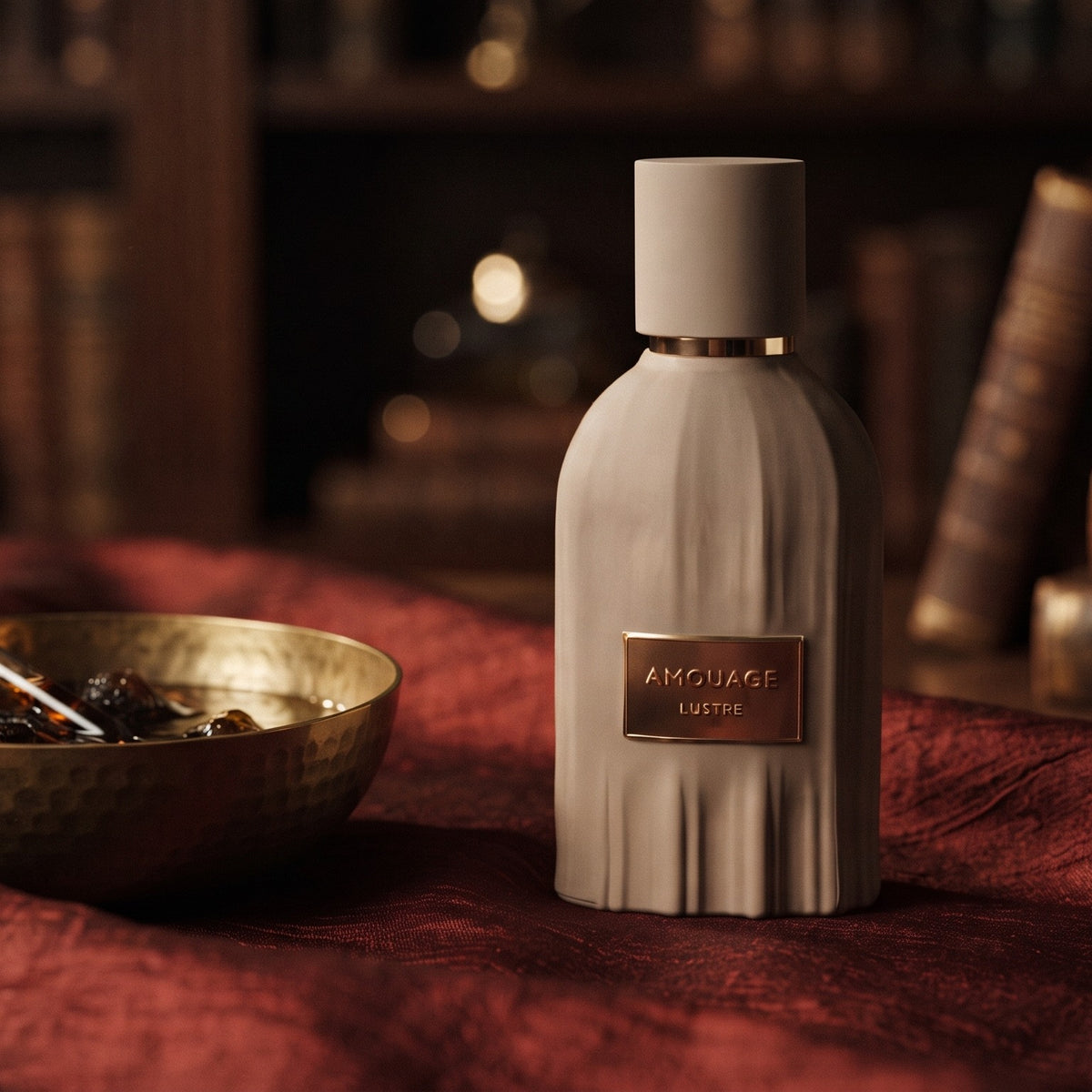Amouage Lustre Essence de Parfum on raw silk of oxblood color with a brass bowl with ambergris tincture